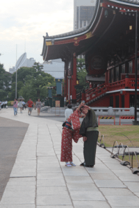 A Japanese couple take a selfie at a Buddhist temple